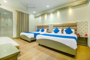 a hotel room with two beds with blue and white pillows at Hotel City Castle in Amritsar