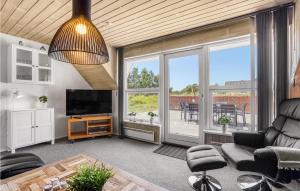 a living room with a couch and a television at Lovely Home In Blåvand With Wifi in Blåvand