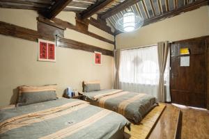 Postel nebo postele na pokoji v ubytování 丽江古城栖旅民宿 qī lǚ lnn old town lijiang