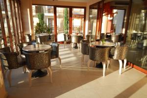 a restaurant with tables and chairs and windows at 4 Epoxes Hotel Spa in Kato Loutraki +26 photos