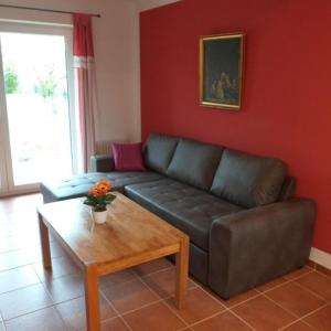 a living room with a couch and a coffee table at Neues ebenerdiges Ferienhaus in Dorenborg in Westoverledingen