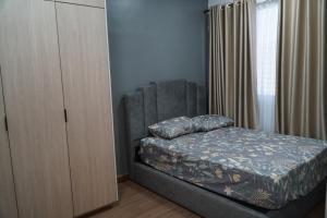 a bedroom with a bed next to a dresser at Cove d'Adelia in Kajang