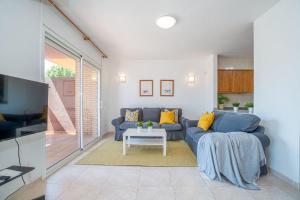 a living room with a blue couch and a table at Jouvacations Villa 2 Freser con piscina compartida in Empuriabrava