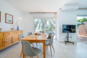 a dining room with a wooden table and chairs at Jouvacations Villa 2 Freser con piscina compartida in Empuriabrava