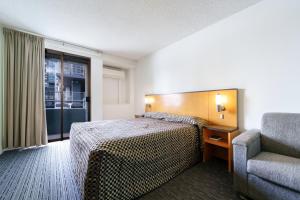 a hotel room with a bed and a chair at Comfort Inn & Suites Goodearth Perth in Perth