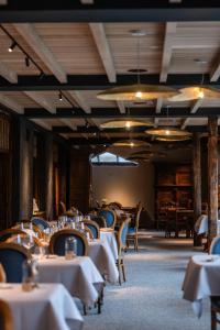 a dining room with white tables and chairs at L'insolite par La Claire Fontaine in La-Roche-en-Ardenne