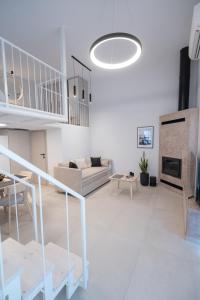 a white living room with a couch and a fireplace at June Home in Platanes