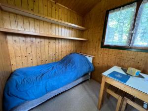 a small room with a bed and a table at Camping de Tauves in Tauves +49 photos