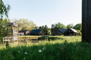a group of buildings in a field next to a river at Les Sources de Cheverny in Cheverny