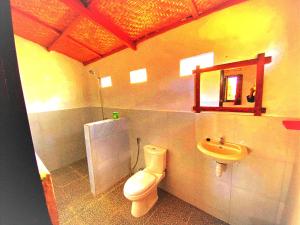 a bathroom with a toilet and a sink at Ariel Bungalow Tetebatu in Tetebatu