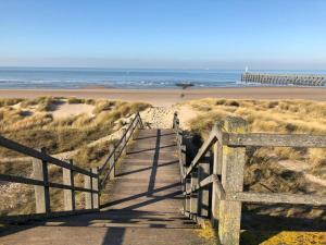 a wooden boardwalk leading to a beach with a pier at Enjoy in Wenduine