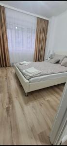 a bedroom with a bed and a wooden floor at Apartament Daria in Timişoara