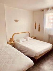 a bedroom with two beds and a window at Hôtel De Normandie in Amiens