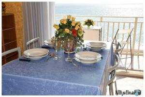 a blue table with plates and a vase of flowers at Bellavista in Mazzeo