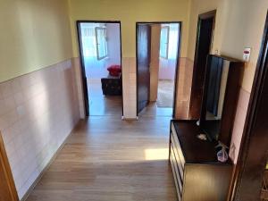 a hallway with two doors and a room with wooden floors at Stefin kutak HOME in Bosanski Novi