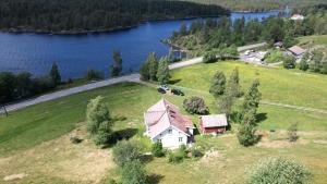 an aerial view of a house on a hill next to a lake at Koselig feriehus Oggevatn in Birkenes