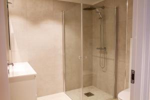una ducha con puerta de cristal en un baño en Avisgata Apartments, en Svolvær 22 fotos más