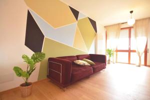 a living room with a couch and a geometric wall at Giotto garden view - pieno centro in Padova