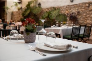 a table with plates and napkins and a wine glass at Hotel Nou Romà in Denia
