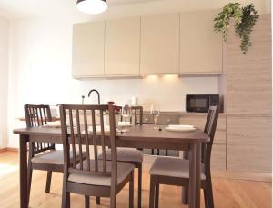 a dining room table with chairs and a kitchen at Giotto garden view - pieno centro in Padova