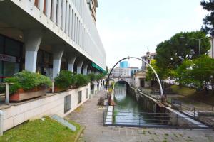 a river next to a building with a bridge at Giotto garden view - pieno centro in Padova
