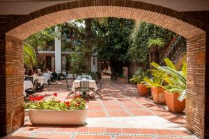 an outdoor patio with tables and chairs and plants at Hotel Nou Rom&agrave; in Denia