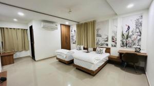 a room with two beds and a desk in it at The Gamora in Gwalior +14 photos