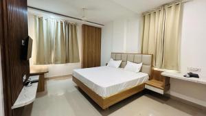 a bedroom with a bed and a television in it at The Gamora in Gwalior