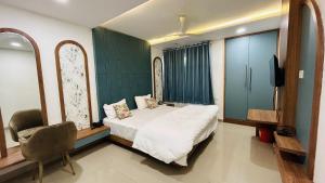 a bedroom with a bed and a tv and a chair at The Gamora in Gwalior