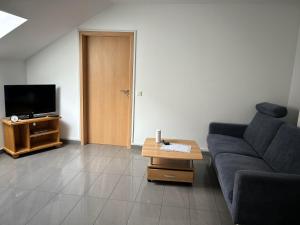 a living room with a couch and a tv at Ferienwohnung Balduin in Sankt Wendel