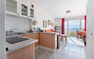 a kitchen with white cabinets and a view of the ocean at Amazing Apartment In Torremolinos in Torremolinos