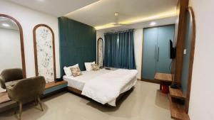 a bedroom with a bed and a chair and a television at The Gamora in Gwalior