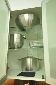 a cabinet filled with pots and pans in a kitchen at Interlaken Town House Sleeps 12 guests Central in Interlaken