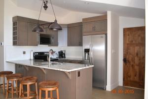 a kitchen with a stainless steel refrigerator and wooden cabinets at Radium Elk Park B & B in Radium Hot Springs
