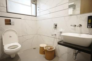 un bagno con un water bianco e un lavandino di A Square Executive Hotel ad Aurangabad
