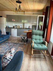 a living room with a couch and chairs and a kitchen at Derya Dağ Evleri in Çamlıhemşin