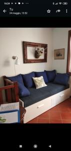 a couch with blue pillows in a living room at CASA VACANZE CERNIZZA in Duino