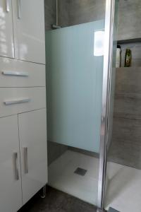 a glass shower in a kitchen with white cabinets at Casa Rosendo Madre in La Guancha +18 photos