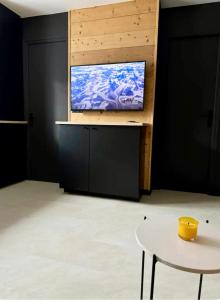 a tv on a wall in a room with a table at Appartement F2 Bis centre de Megève in Megève