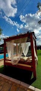 a wooden bed with a canopy and white curtains at Apartmani Neven in Irig