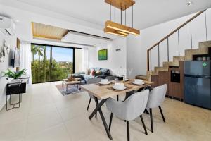 a dining room and living room with a table and chairs at Belle Vue by Kozystay - Dago in Bandung