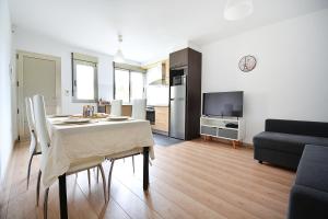 eine Küche und ein Wohnzimmer mit einem Tisch und einer Couch in der Unterkunft Apartamento con terraza en San Vicente in O Grove