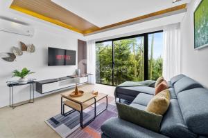 a living room with a couch and a tv at Belle Vue by Kozystay - Dago in Bandung