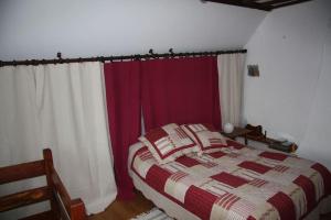 a bedroom with a bed with red and white curtains at Cottage chaleureux avec Cheminée au Calme in Beaubery