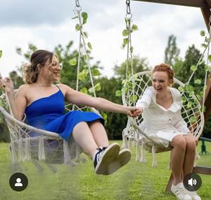 two women sitting on a swing at Apartmani Neven in Irig