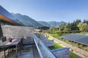 a balcony of a house with a table and chairs at Residenz Wildkogelbahnen Top 11 in Neukirchen am Großvenediger