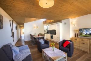 a living room with a couch and a table and a kitchen at Residenz Wildkogelbahnen Top 11 in Neukirchen am Großvenediger