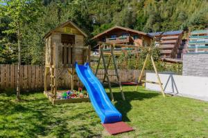 a playground with a blue slide in a yard at Residenz Wildkogelbahnen Top 18 in Neukirchen am Großvenediger