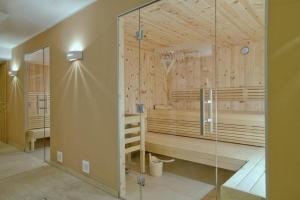 a sauna with wooden walls and a glass door at Residenz Wildkogelbahnen Top 18 in Neukirchen am Großvenediger +21 photos