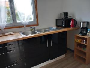 a kitchen counter with a sink and a microwave at THALASSA in Audresselles +52 photos